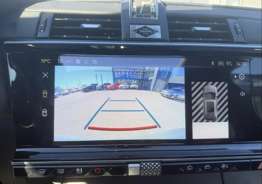 Écran central du DS7 1.5 HDI 130cv 2025 montrant la caméra de recul avec vue arrière sur un parking en extérieur.