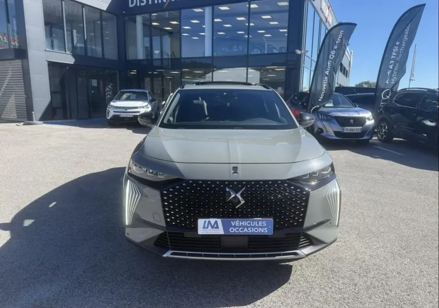 Vue frontale d’un DS7 1.5 HDI 130cv Étoile gris métal avec calandre noire à motifs losanges et feux LED verticaux.
