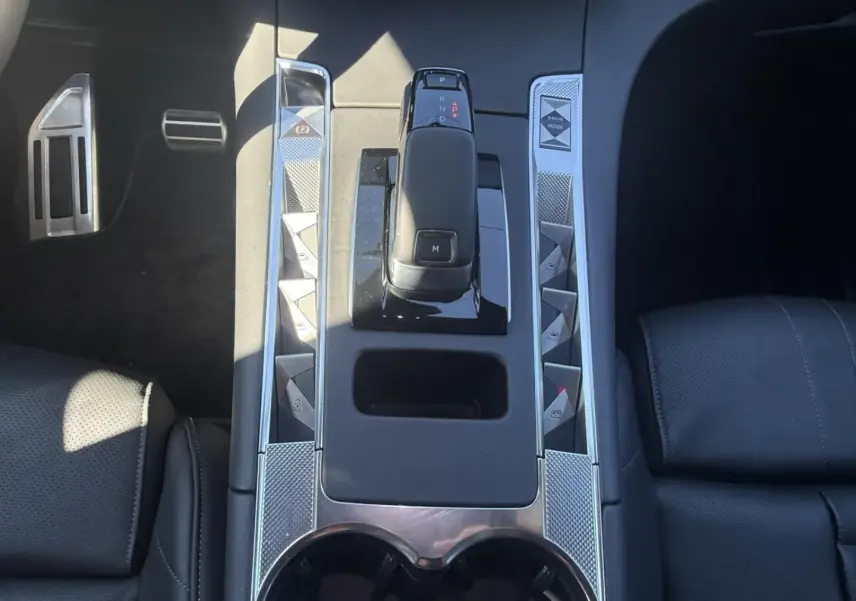 Gros plan sur la console centrale du DS7 1.5 HDI 130cv Gris métal 2025, avec levier de vitesses automatique et sièges noirs.