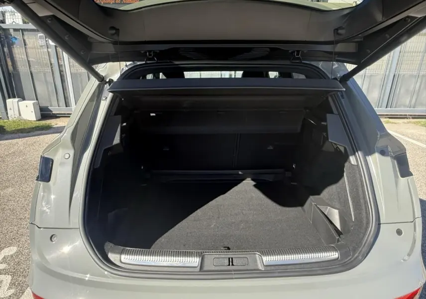 Coffre ouvert vu de l'arrière d'un DS7 1.5 HDI gris métal 2025, montrant un espace de chargement spacieux et propre.