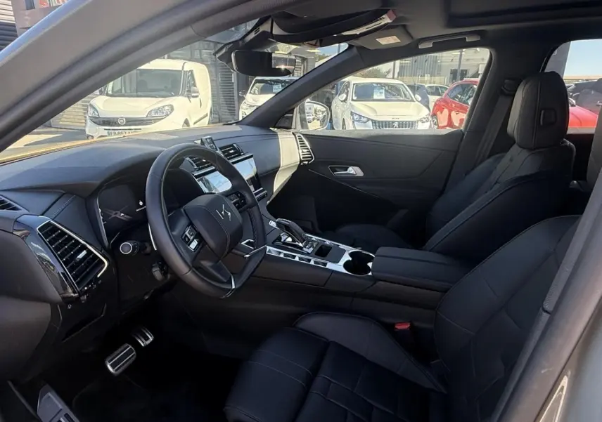 Intérieur du DS7 1.5 HDI 130cv Etoile 2025 en gris métal, vue côté conducteur montrant tableau de bord et sièges noirs cuir.