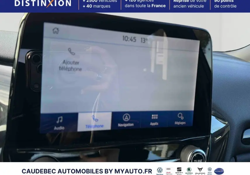 Vue intérieure centrée sur l'écran tactile du système SYNC4 du Ford Puma bleu 2024, avec commandes vocales visibles.