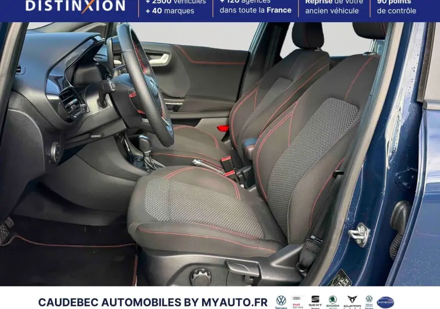 Vue intérieure côté conducteur du Ford Puma bleu 2024, sièges sport noirs avec surpiqûres rouges et volant cuir.