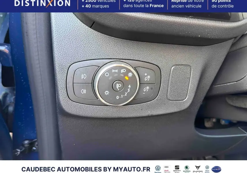 Gros plan sur le panneau de commande des phares côté gauche d'une Ford Puma bleue 2024 avec réglages lumineux.