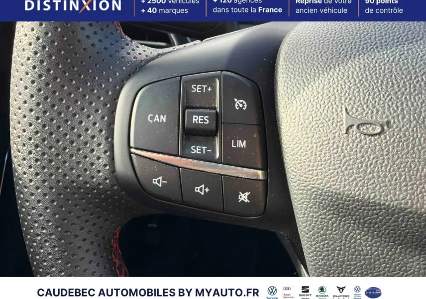 Gros plan sur les commandes de régulateur de vitesse au volant perforé avec surpiqûres rouges du Ford Puma bleu 2024.
