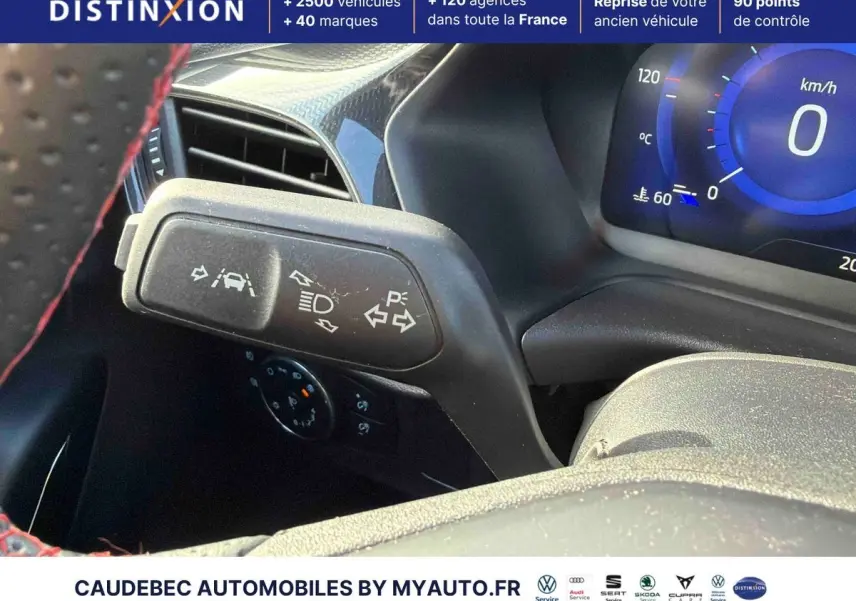 Gros plan sur la commande de clignotants et feux du Ford Puma 2024, intérieur noir avec surpiqûres rouges au volant.