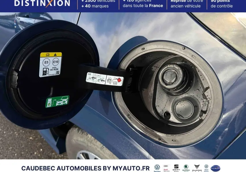 Gros plan sur la trappe à carburant ouverte d'une Ford Puma bleue, montrant le bouchon essence et les consignes.