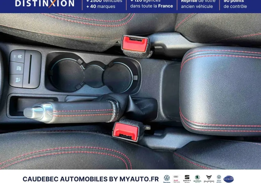 Vue plongeante sur la console centrale du Ford Puma 2024, avec frein à main et surpiqûres rouges visibles.