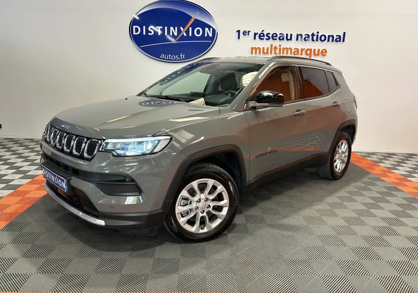 Jeep Compass Limited gris en 3/4 avant droit, SUV hybride avec jantes alliage et calandre distinctive.