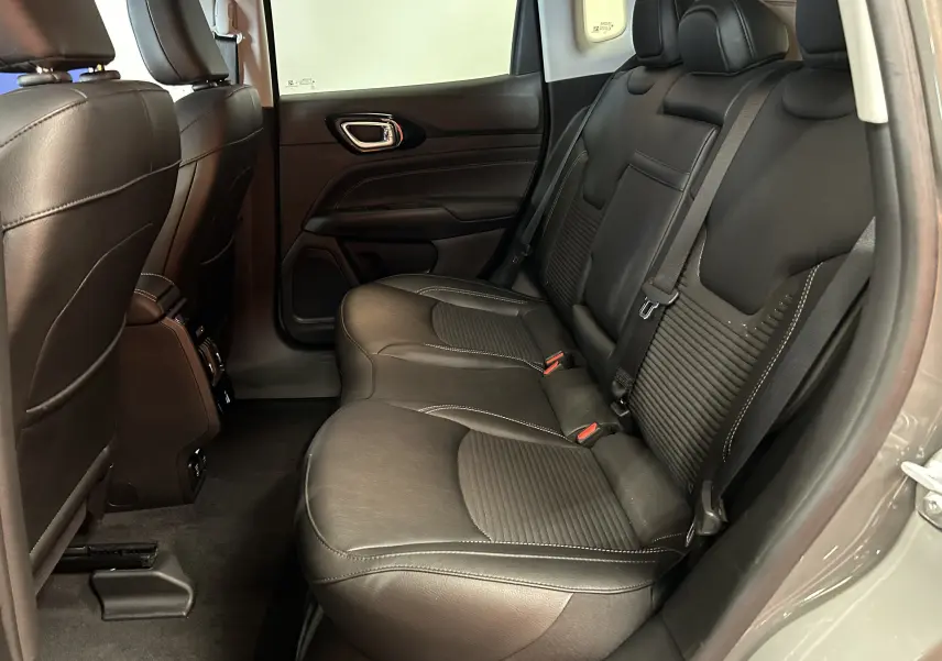 Vue intérieure arrière côté droit du Jeep Compass Limited 2021, sièges en cuir noir avec surpiqûres blanches.