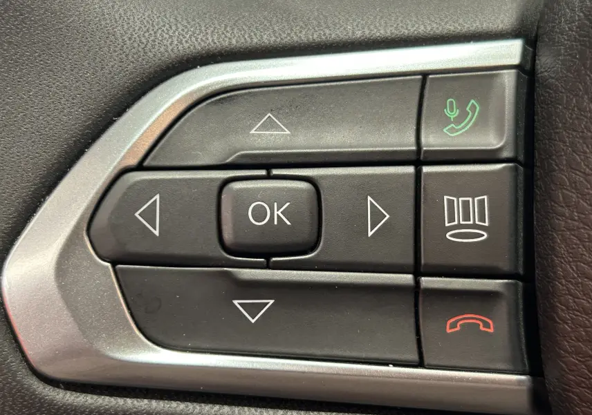 Gros plan sur les commandes multifonctions noires et argentées au volant du Jeep Compass gris Limited 2021.