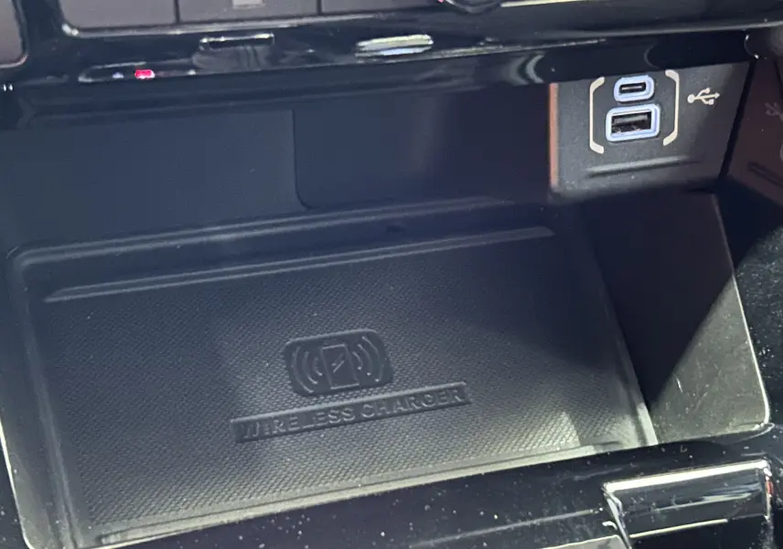 Gros plan sur le chargeur sans fil et ports USB dans l'habitacle du Jeep Compass Limited gris 2021.