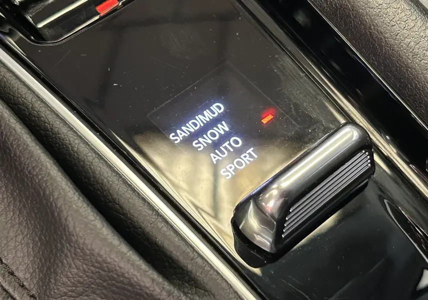 Gros plan sur la commande de modes de conduite du Jeep Compass Limited gris, avec options sable, neige, auto et sport.