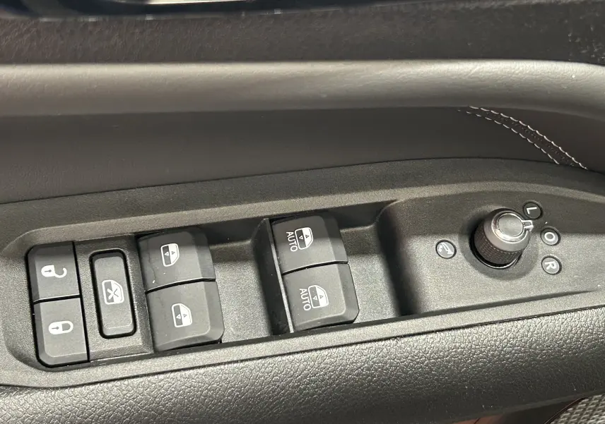 Commandes des vitres électriques et réglage des rétroviseurs sur la porte côté gauche d'un Jeep Compass gris 2021.