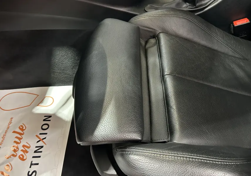 Gros plan sur le siège avant en cuir noir chauffant de la BMW Série 3 320i blanc, intérieur soigné et confortable.