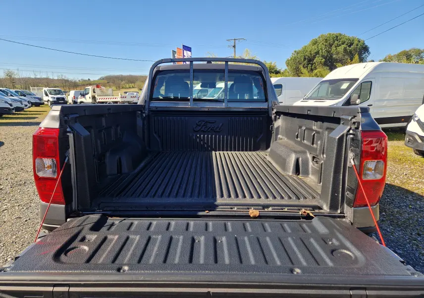 Vue arrière du Ford Ranger Super Cabine gris carbone 2026, mettant en valeur la benne ouverte avec revêtement antidérapant noir.