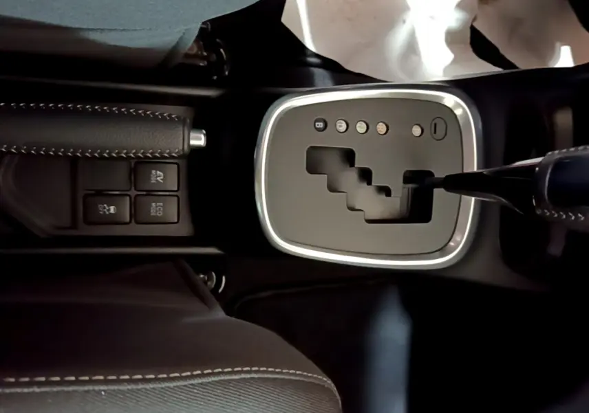 Gros plan sur la console centrale noire de la Toyota Yaris 1.5 Hybride 2020, montrant la boîte auto et les boutons de mode de conduite.