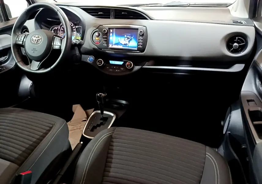 Intérieur de la Toyota Yaris 1.5 Hybride 2020, vue de face côté conducteur, tableau de bord noir avec écran tactile central.