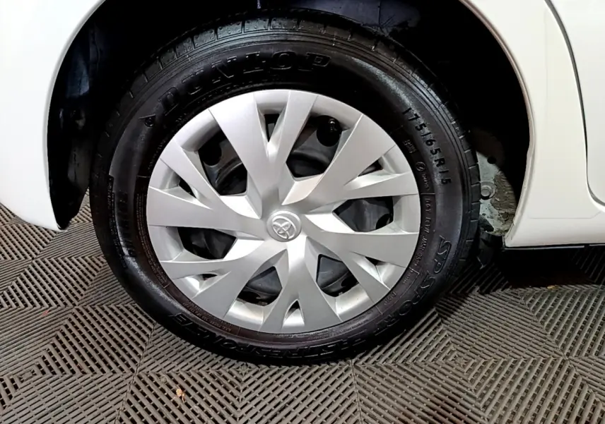 Gros plan sur la roue avant droite blanche d'une Toyota Yaris 1.5 Hybride 2020 avec enjoliveur argenté au design moderne.