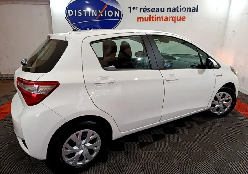 Profil côté droit d'une Toyota Yaris blanche 1.5 Hybride 2020, avec jantes alliage et vitres teintées.