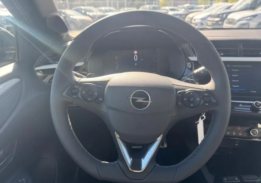 Vue frontale du volant noir de l’Opel Corsa 2025 avec commandes intégrées et tableau de bord digital.
