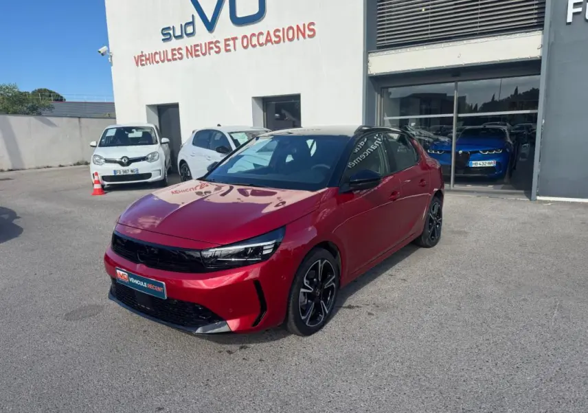 Opel Corsa rouge vue 3/4 avant droit, jantes alliage noires, toit noir et calandre noire brillante.