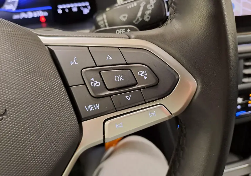 Gros plan sur les commandes au volant côté gauche du Volkswagen Polo 1.0 TSI 116 DSG7 R-Line Edition, intérieur noir.