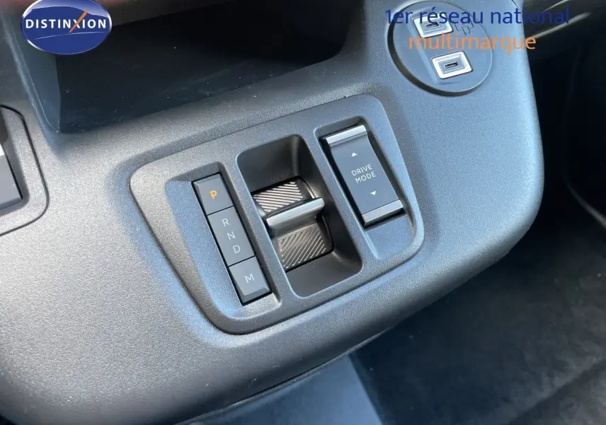 Gros plan sur la console centrale du Citroën Berlingo noir, montrant la commande de boîte auto et le sélecteur Drive Mode.