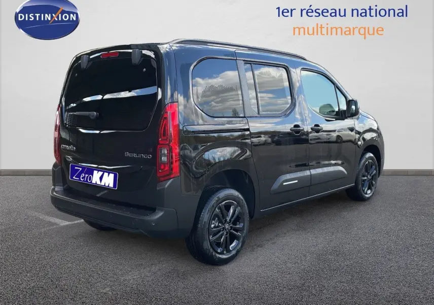 Vue 3/4 arrière droite d’un Citroën Berlingo noir Perla Nera métallisé avec vitres teintées et jantes noires brillantes.