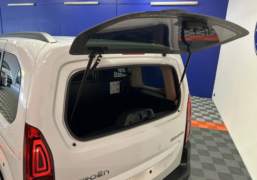 Vue arrière droite d'un Citroën Berlingo Multispace blanc Kaolin avec hayon ouvert et lunette arrière relevée.