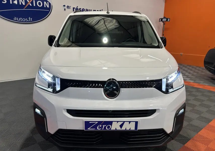 Vue avant du Citroën Berlingo Multispace blanc Kaolin avec phares LED allumés et logo noir brillant au centre.