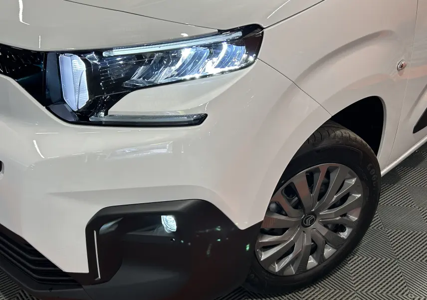 Gros plan sur l’avant droit blanc Kaolin du Citroën Berlingo Multispace 2026 avec phare LED et antibrouillard allumé.