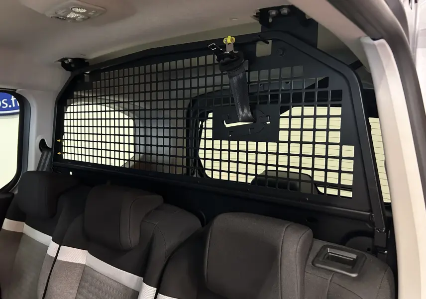 Vue intérieure arrière du Citroën Berlingo Multispace blanc Kaolin, montrant la grille de séparation et les sièges tissu noirs et gris.