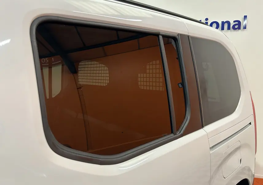 Vue latérale arrière droite du Citroën Berlingo Multispace blanc Kaolin avec vitre surteintée et porte coulissante.