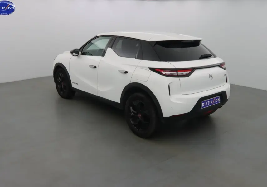 Vue 3/4 arrière droite d'un DS3 Crossback blanc banquise avec jantes noires et toit contrasté noir.