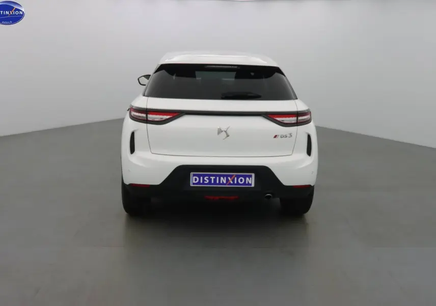 Vue arrière d'une DS3 Crossback blanche Banquise avec feux LED et vitre arrière teintée dans un studio.