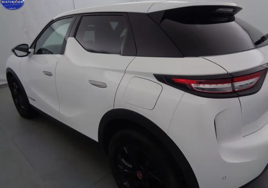 Vue 3/4 arrière droite d'un DS3 Crossback blanc banquise avec toit noir et jantes noires.