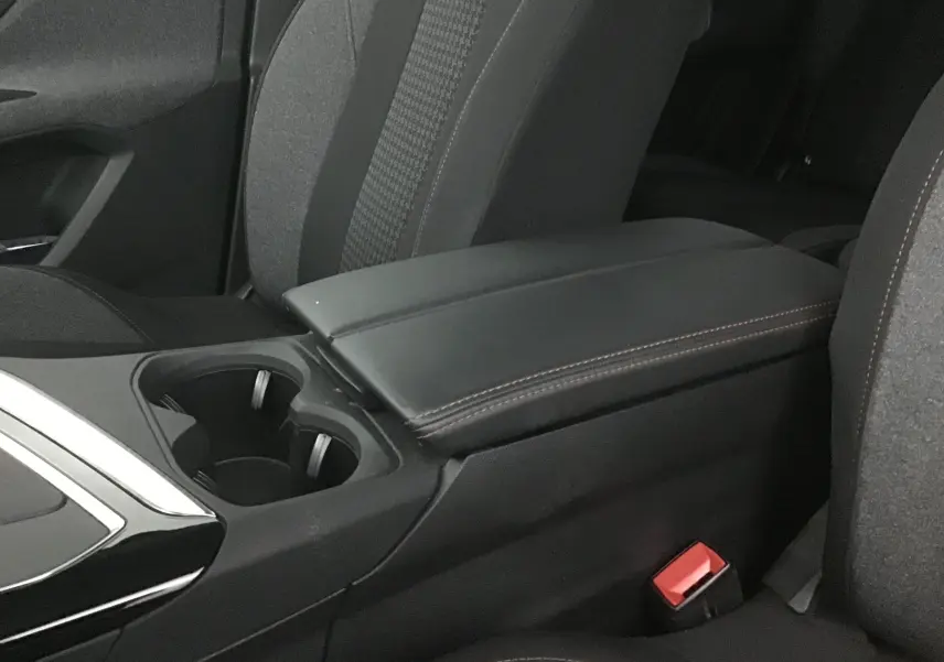 Gros plan sur l'accoudoir central en cuir noir et porte-gobelets entre les sièges avant du Peugeot 5008 noir 2019.