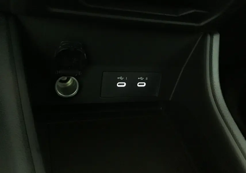 Prise allume-cigare et deux ports USB éclairés dans la console centrale du Renault Captur bleu iron/noir 2025.