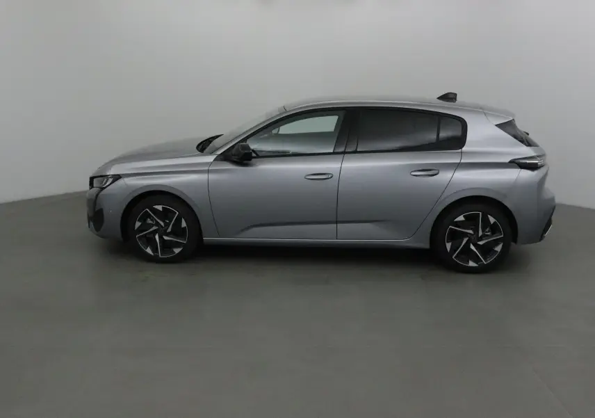 Peugeot 308 gris Artense vue de profil côté gauche, soulignant ses jantes alliage noires et lignes épurées.
