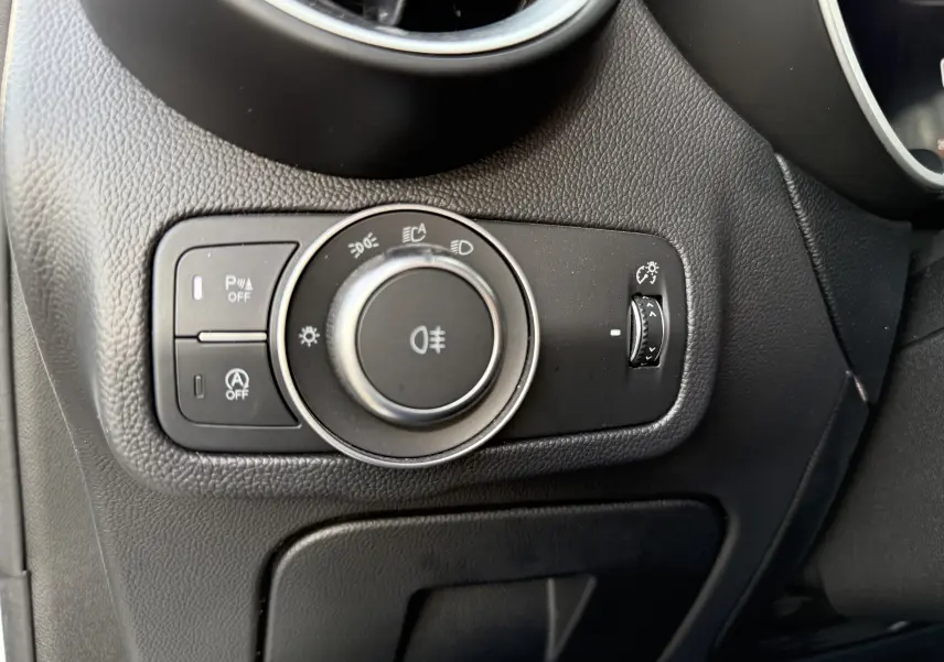 Gros plan sur le panneau de commande d'éclairage noir à gauche du volant dans l'Alfa Romeo Stelvio blanc 2023.