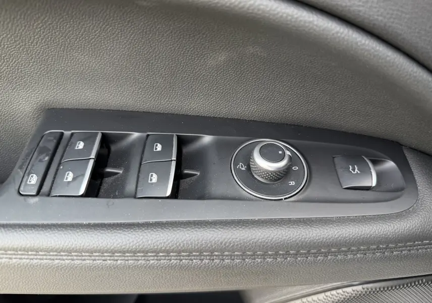 Gros plan sur les commandes de fenêtre et rétroviseurs côté gauche d'un Alfa Romeo Stelvio blanc 2023 finition Sprint.