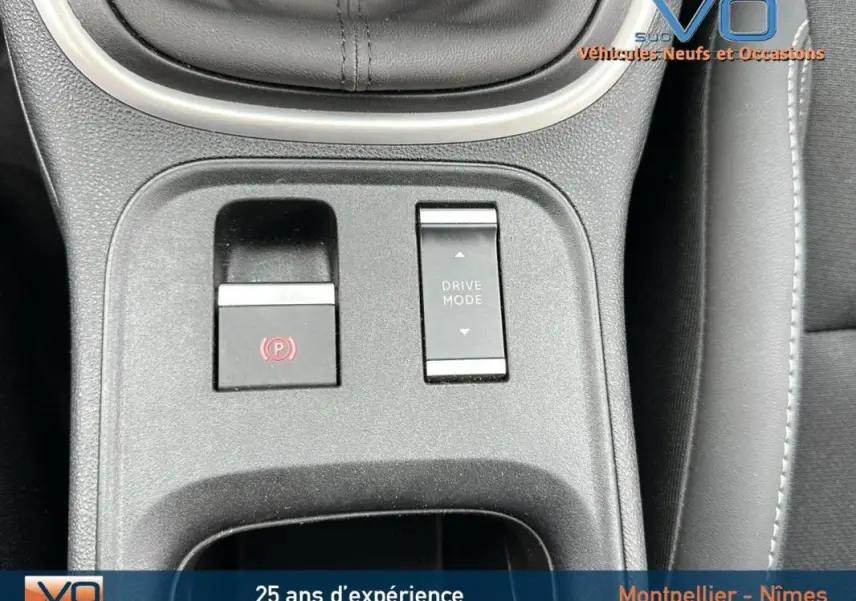 Gros plan sur la console centrale du Jeep Avenger 2024 montrant les boutons frein électronique et mode de conduite.