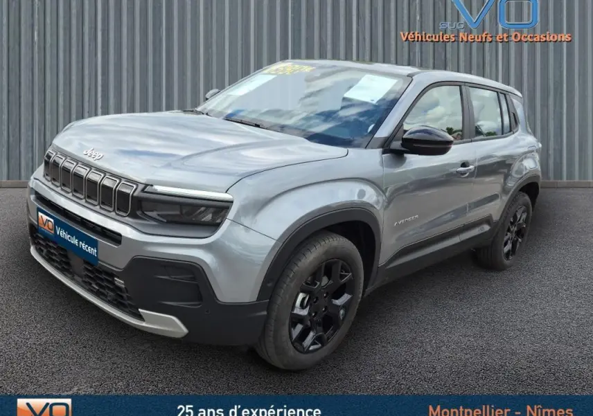 Jeep Avenger gris foncé vu en 3/4 avant droit, mettant en valeur sa calandre distinctive et ses jantes noires.