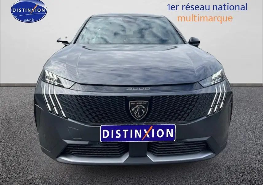 Vue frontale d'un Peugeot 3008 gris titane 2025 avec calandre noire et feux LED distinctifs en griffes.