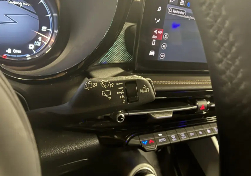 Gros plan sur la commande d’essuie-glace à gauche du volant dans l’habitacle noir de l’Alfa Romeo Tonale gris foncé 2023.