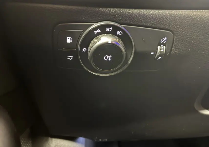 Gros plan sur le bouton de commande des phares et éclairages intérieurs noirs de l'Alfa Romeo Tonale 1.3 PHEV 280 BVA TI 2023.