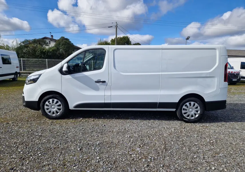 Vue de profil côté gauche d’un utilitaire Nissan Primastar blanc, version L2H1 avec jantes acier et enjoliveurs.