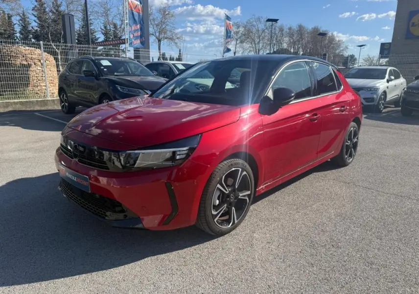 Opel Corsa rouge vue 3/4 avant droit, toit noir, jantes alliage noires et détails modernes sur calandre.