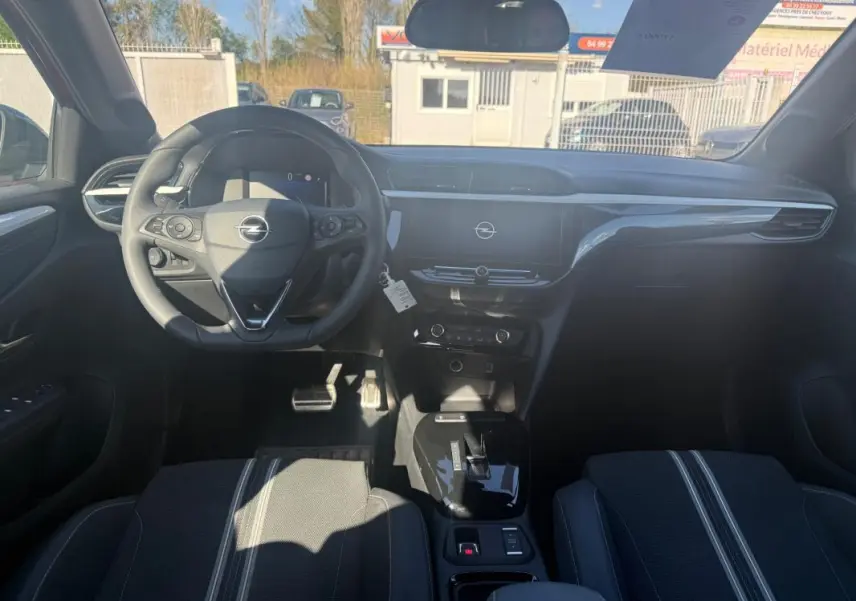 Vue intérieure avant de l’Opel Corsa 2025, tableau de bord et volant noirs avec écran central tactile.